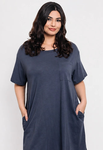 Woman wearing a blue dress with pockets on a white background