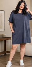 Woman wearing a navy blue t-shirt dress in a living room setting.